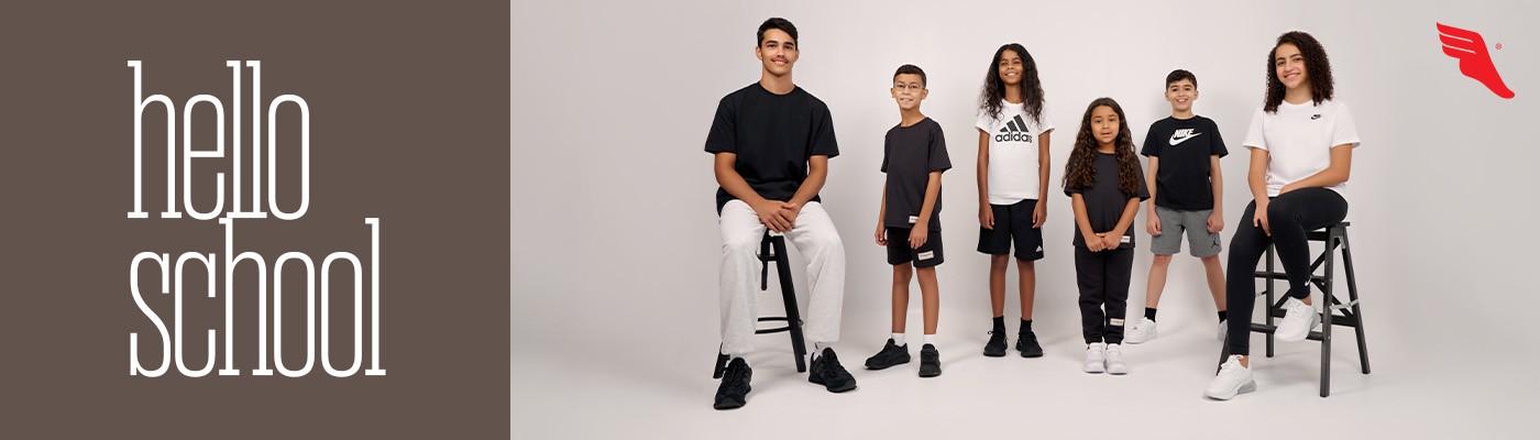 simple white desk on a white wall with a plant on the far right side